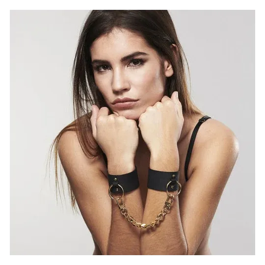 Wide black bondage cuffs in vegan leather by Bijoux Maze, dual use as bracelet and handcuffs with chain.